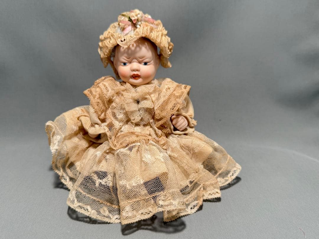 レースドレスをまとったベビーのアンティークドール。陶器製2フェイス